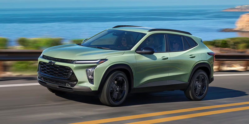 Green Chevrolet Trax on a coastal road.